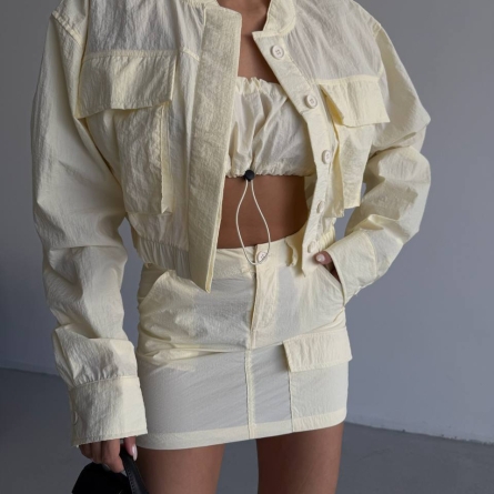 Тройной кремовый комплект: укороченная куртка, топ и мини-юбка