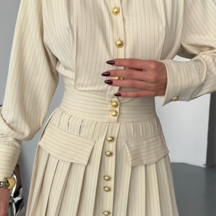 Кремовое платье-рубашка с золотыми пуговицами и плиссированной юбкой
